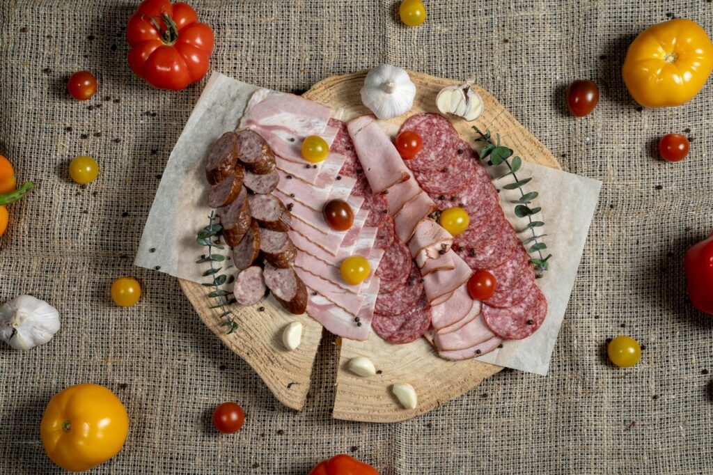 A flavorful assortment of meats and vegetables displayed on a rustic board.